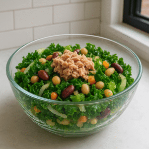 Quick healthy lunch recipes — vibrant kale and fennel bean salad with tuna, served in a clear glass bowl with white beans, lemon dressing, and fresh herbs on a bright kitchen counter.