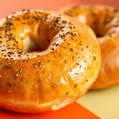Classic New York-style plain bagels stacked on a wooden board, golden brown with a chewy texture, perfect for authentic NYC breakfast at home.